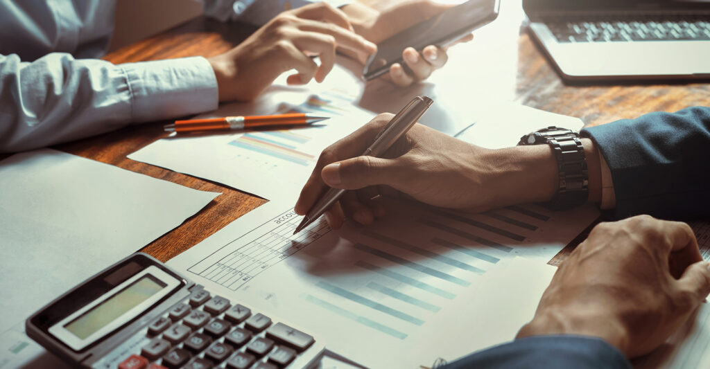 A view of two people's hands while they work on taxes